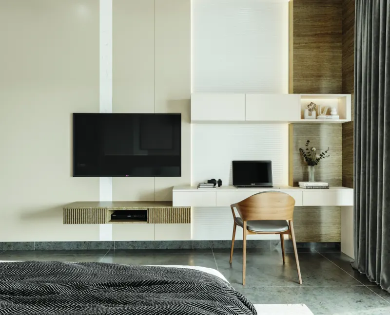 Bedroom with a wall-mounted TV unit and a study desk in a 3 BHK home in Hosur, designed by Huma Interiors