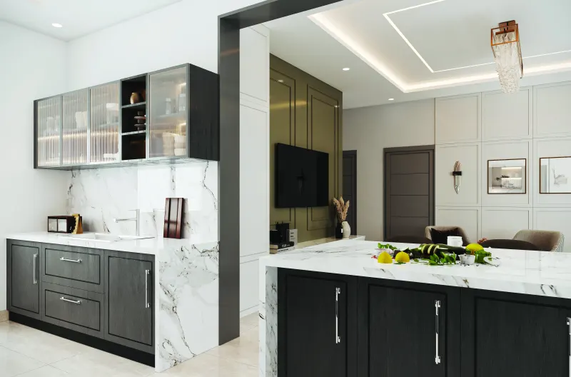 Kitchen with dark grey cabinets, glass wall units and a breakfast counter in a 2 BHK home in Bagaluru, designed by Huma Interiors